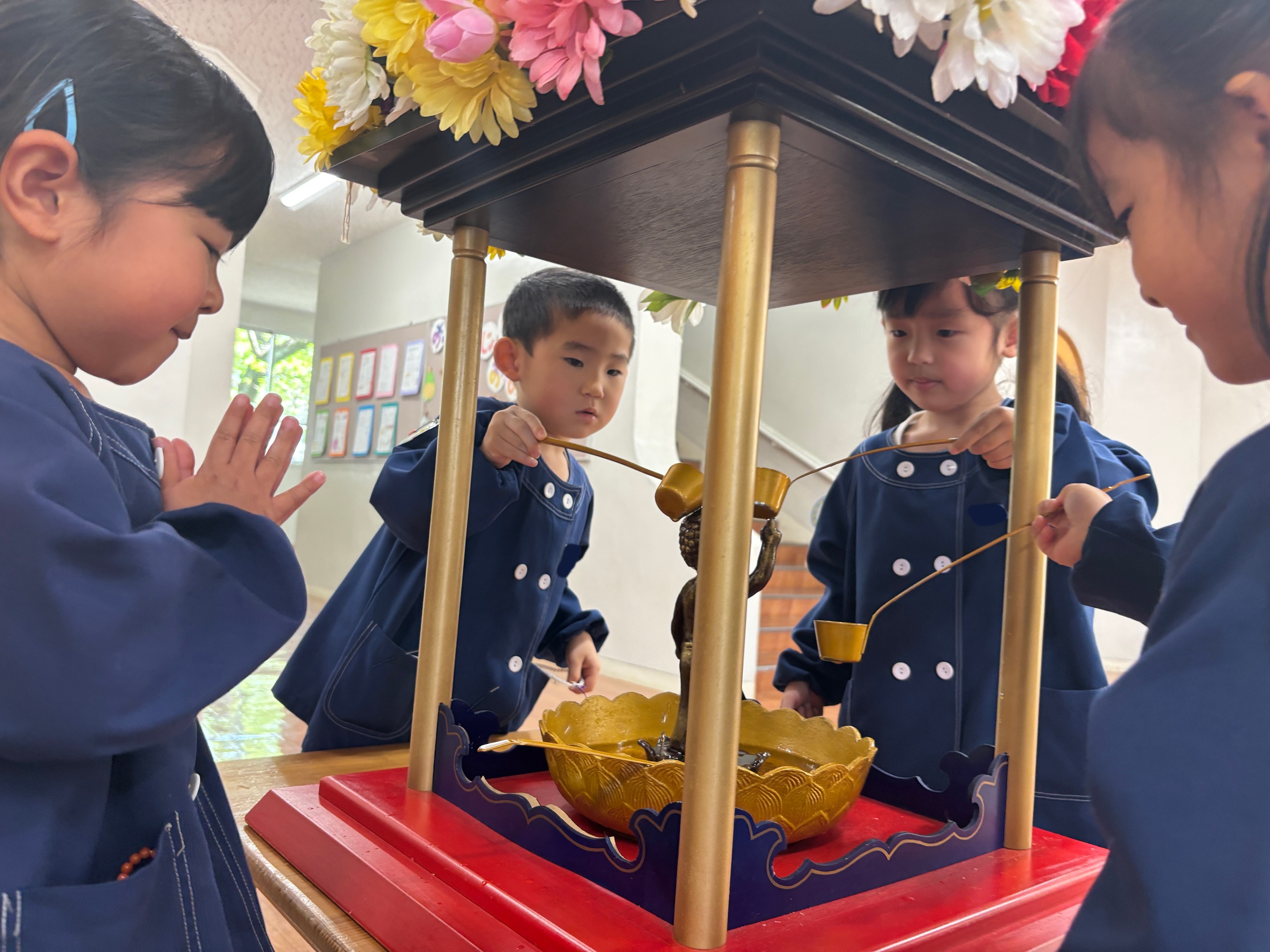 仏様の前で静かに手を合わせる敬愛幼稚園の園児たち