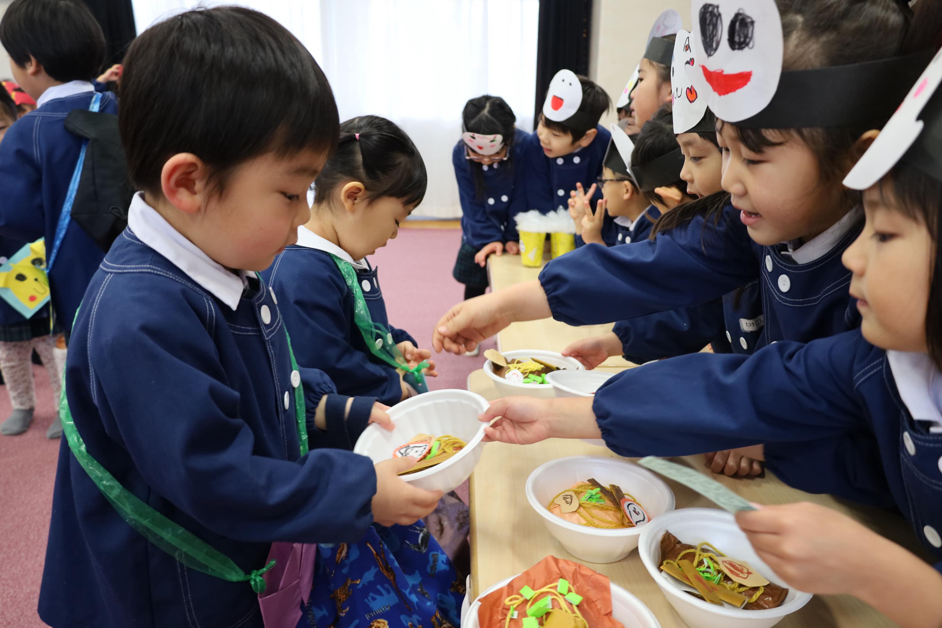 年上の園児が年下の園児の世話をする様子